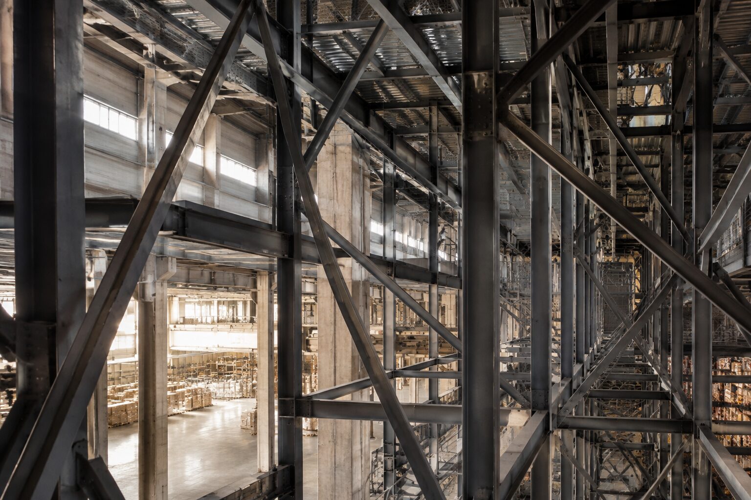 Structural steelwork of a distribution building with the racked warehouse floor visible below
